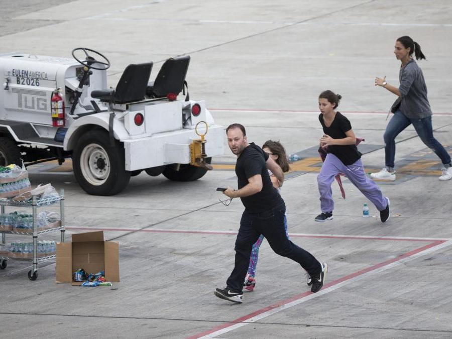 Persone che scappano sulla pista dell’aeroporto. (AP Photo/Wilfredo Lee)