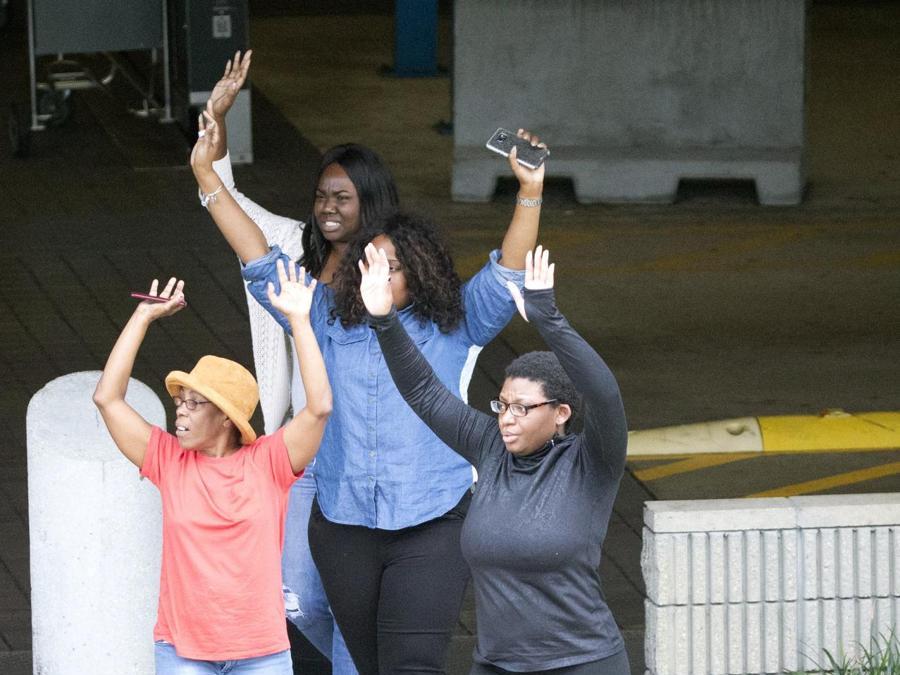 Persone che escono dal garagecon le mani in alto. (AP Photo/Wilfredo Lee)
