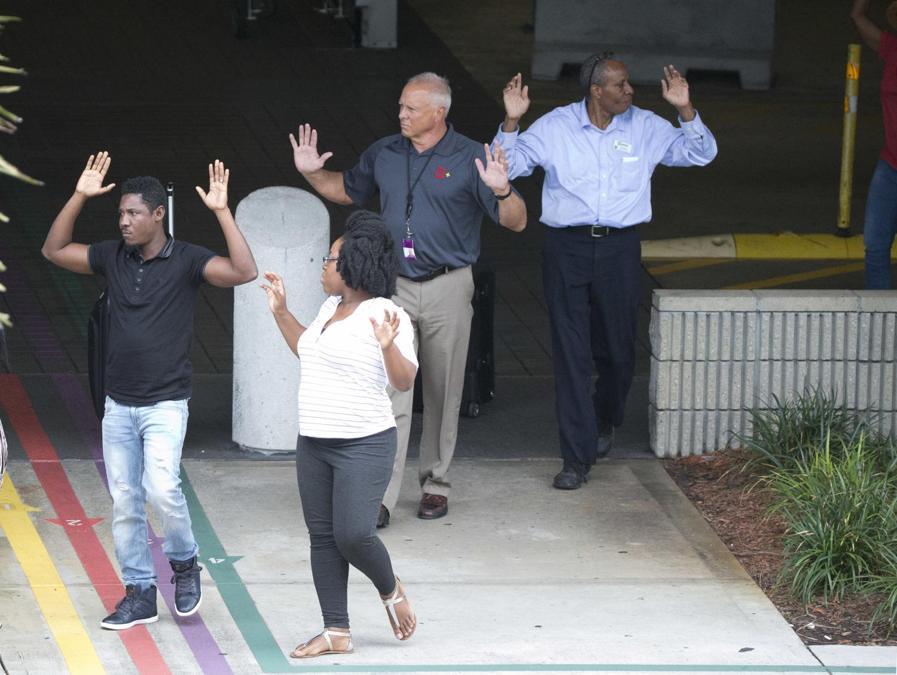 Persone che escono dal garagecon le mani in alto. (AP Photo/Wilfredo Lee)