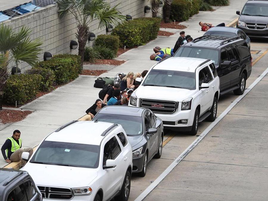 Persone si mettono al riparo dietro le automobili. (Joe Raedle/Getty Images/AFP)
