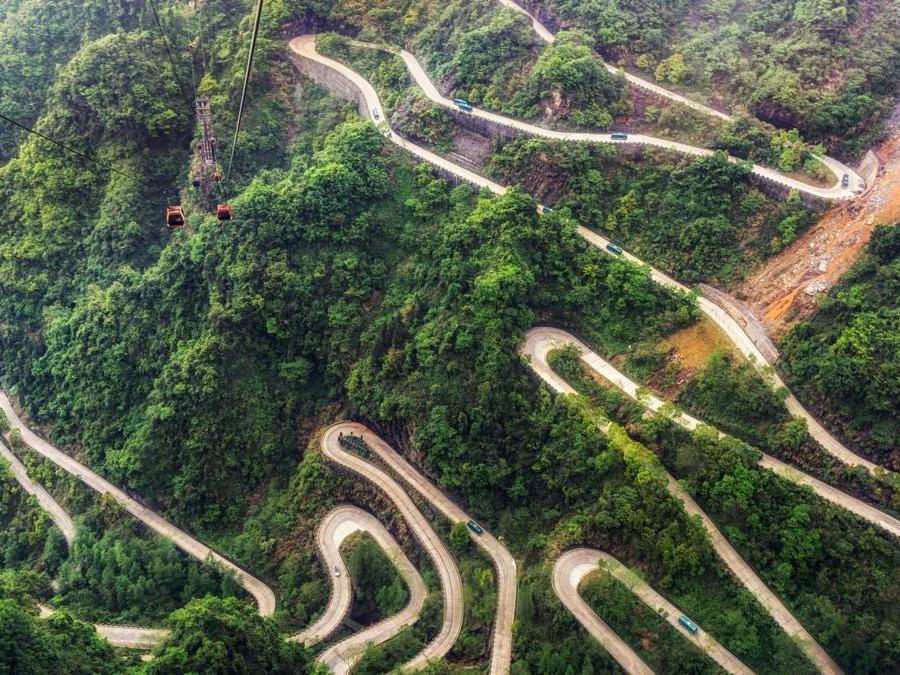 CINA . Il Tianmen Shan Grande Porta Road (chiamato anche il Tianmen Winding) è una strada di montagna lunga 11 chilomerti. La leggenda narra che abbia 99 curve, che simboleggiano i nove palazzi del cielo. (OLYCOM)