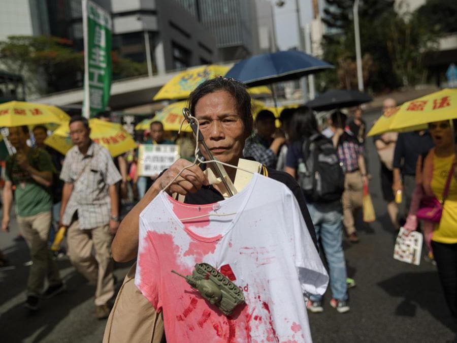 Un attivista pro-democrazia mostra una maglietta ricoperta di sangue finto e un serbatoio giocattolo durante una marcia per commemorare il massacro di Tiananmen del 1989, a Hong Kong, in Cina, il 26 maggio 2019. ANSA/JEROME FAVRE
