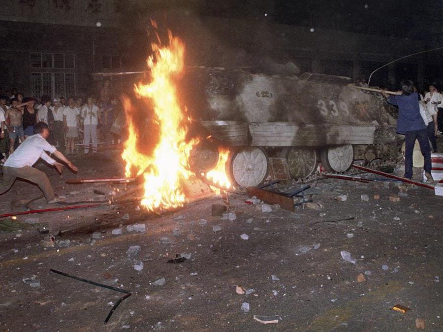 In questa foto del 4 giugno 1989, un manifestante studentesco mette barricate sul percorso di un mezzo corazzato blindato in fiamme. (AP Photo/Jeff Widener, File)