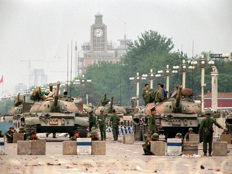 Questa foto di archivio scattata il 6 giugno 1989 mostra carri armati dell'Esercito di Liberazione Popolare (PLA) e soldati che sorvegliavano la Chang'an Avenue che portava a Piazza Tiananmen a Pechino. (Photo by Manny CENETA / AFP)