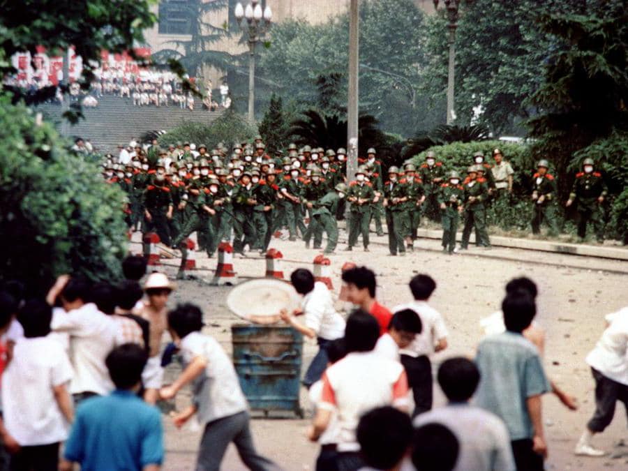 Questa foto di archivio presa il 4 giugno 1989 mostra cittadini e studenti cinesi che lanciano sassi alle truppe durante gli scontri a seguito della proclamazione della legge marziale nella città di Chengdu, capitale della provincia cinese del Sichuan. (Photo by - / AFP)