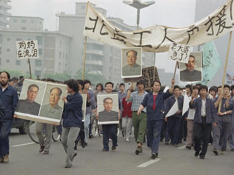 In questa foto del 18 maggio 1989, i dimostranti democratici portano i ritratti degli ex sovrani cinesi Mao Tse-Tung e Chou En-Lai mentre marciavano per raggiungere gli studenti scioperanti in Piazza Tiananmen, a Pechino(AP Photo/Sadayuki Mikami, File)