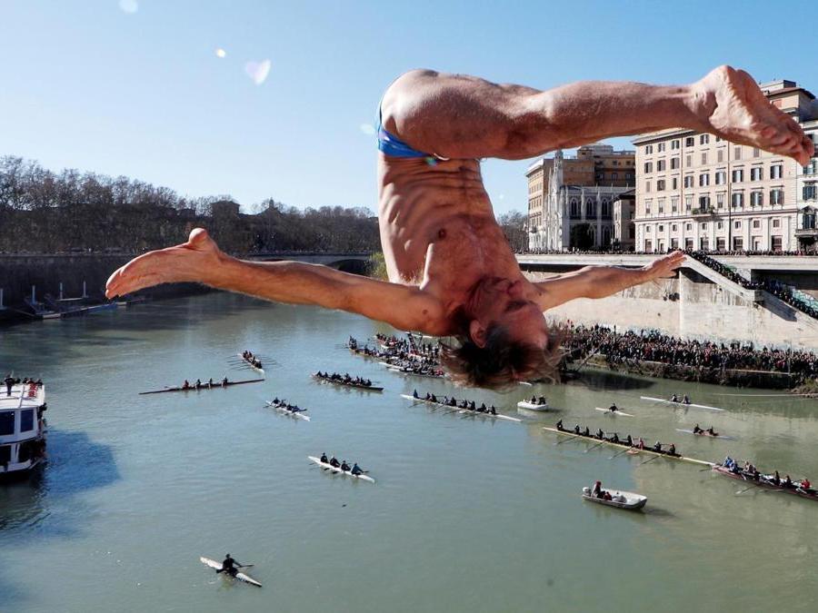 Marco Fois  si  tuffa nel fiume Tevere dal ponte Cavour,  alto 18 metri  durante la tradizionale immersione annuale di Capodanno, a Roma. REUTERS/Alessandro Bianchi