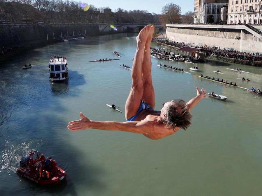 Marco Fois  si tuffa nel fiume Tevere dal ponte Cavour,  alto 18 metri  durante la tradizionale immersione annuale di Capodanno, a Roma. REUTERS/Alessandro Bianchi