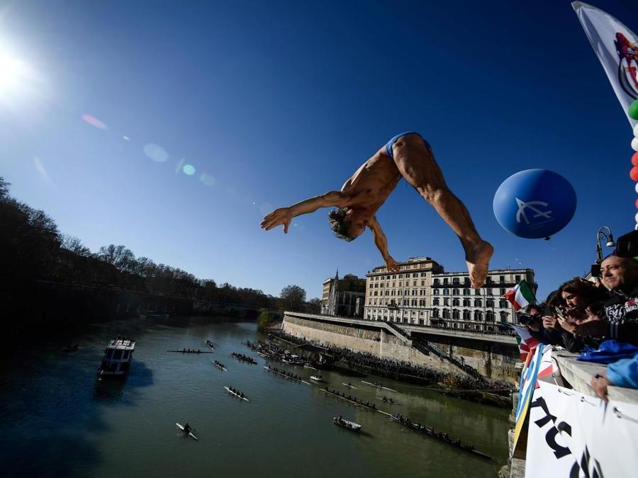 Marco Fois  si  tuffa nel fiume Tevere dal ponte Cavour,  alto 18 metri  durante la tradizionale immersione annuale di Capodanno, a Roma. (Photo by Filippo MONTEFORTE / AFP)