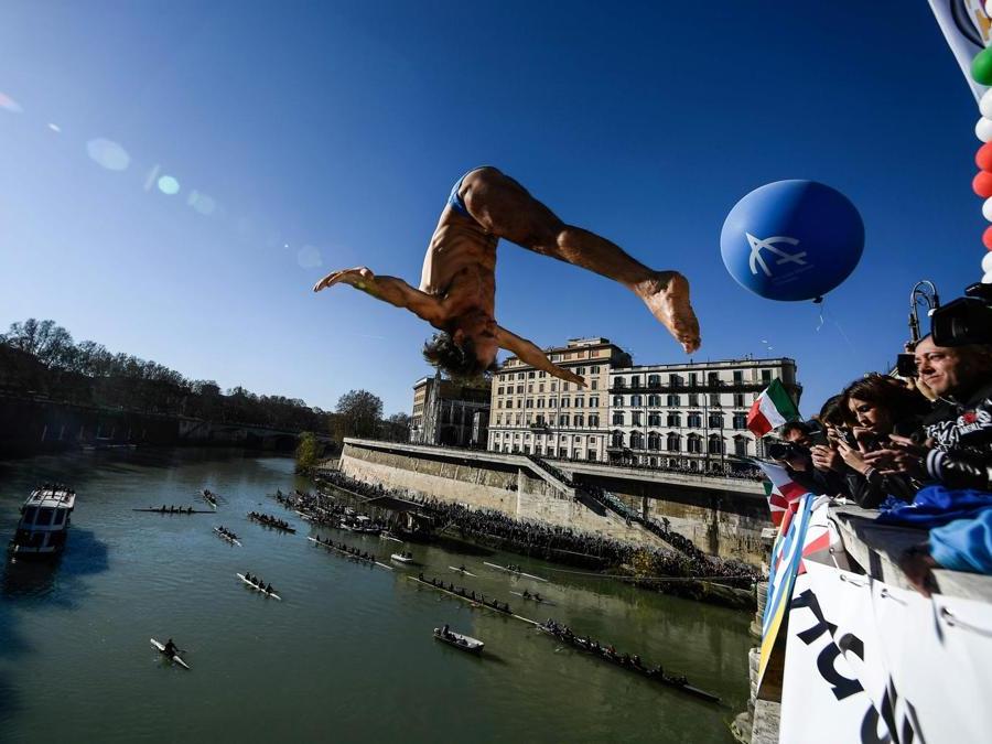 Marco Fois  si tuffa tuffa nel fiume Tevere dal ponte Cavour,  alto 18 metri  durante la tradizionale immersione annuale di Capodanno, a Roma. (Photo by Filippo MONTEFORTE / AFP)
