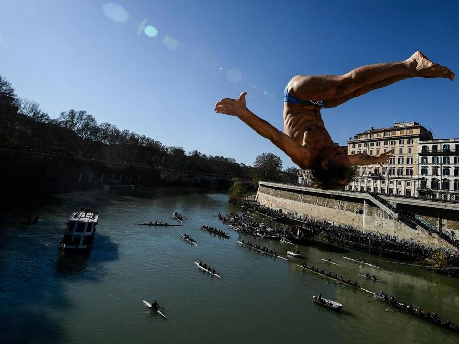 Marco Fois  si  tuffa nel fiume Tevere dal ponte Cavour,  alto 18 metri  durante la tradizionale immersione annuale di Capodanno, a Roma.  (Photo by Filippo MONTEFORTE / AFP)