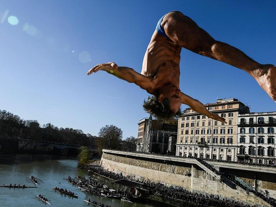 Marco Fois  si  tuffa nel fiume Tevere dal ponte Cavour,  alto 18 metri  durante la tradizionale immersione annuale di Capodanno, a Roma. (Photo by Filippo MONTEFORTE / AFP)