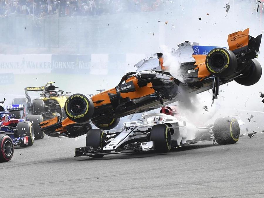 Il pilota della Mclaren Fernando Alonso vola sulla Sauber guidata da Charles Leclerc alla partenza del Grand Prix di Spa-Francorchamps, Belgio (AP Photo/Geert Vanden Wijngaert)