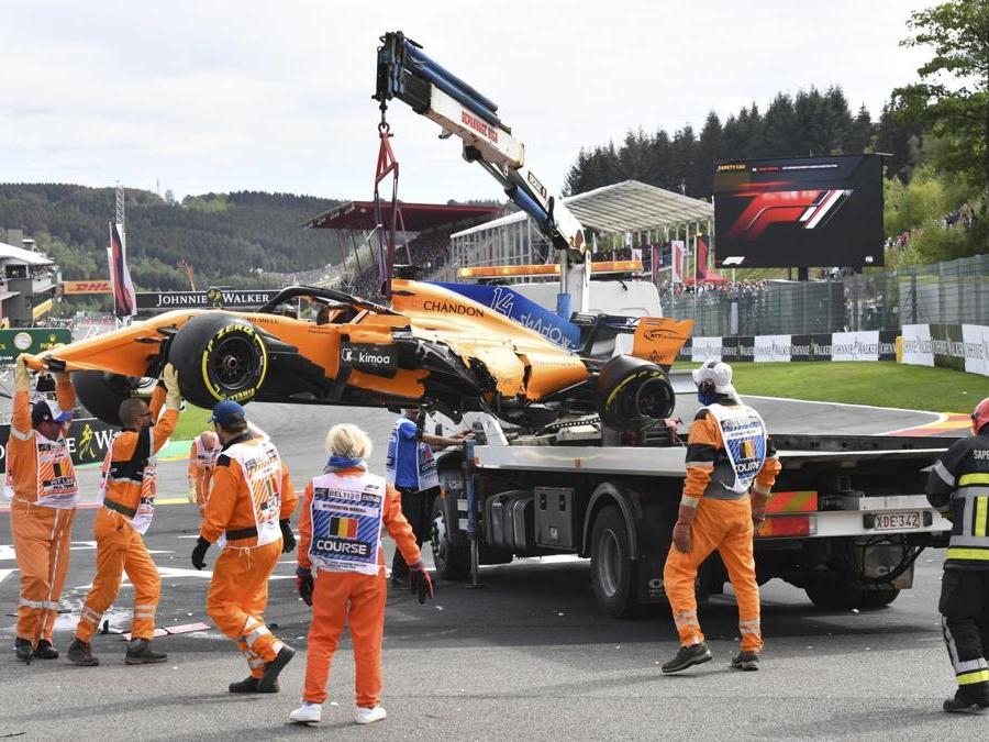 La Mclaren di Fernando Alonso viene sgomberata dalla pista (AP Photo/Geert Vanden Wijngaert)