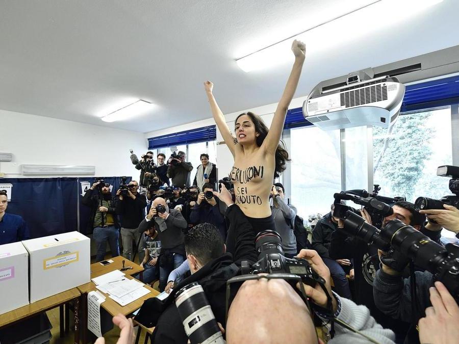 Milano, protesta di un'attivista Femen nel seggio elettorale dove vota Silvio Belrusconi (Agf)