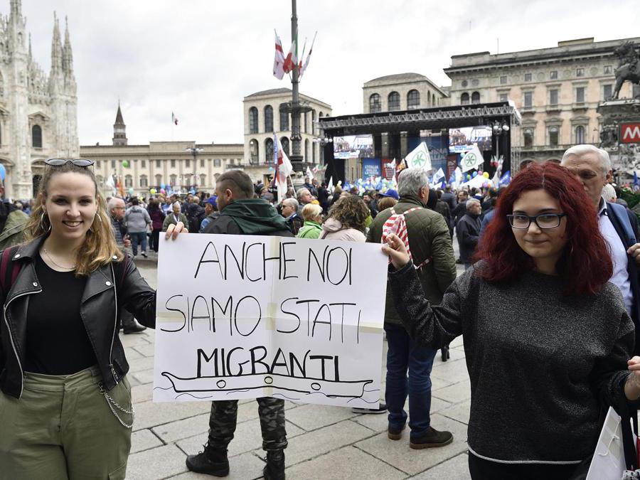 Due ragazze mostrano un cartello di contestazione durante la manifestazione della Lega in piazza Duomo “Prima l'Italia. Il buon senso in Europa”. (Ansa/Flavio Lo Scalzo)