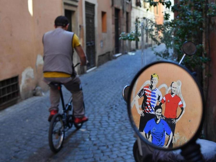 Un murales con Giuseppe Conte, Donald Trump e Vladimir Putin in tenuta calcistica in vicolo del Fico nel centro di Roma. ANSA/ALESSANDRO DI MEO