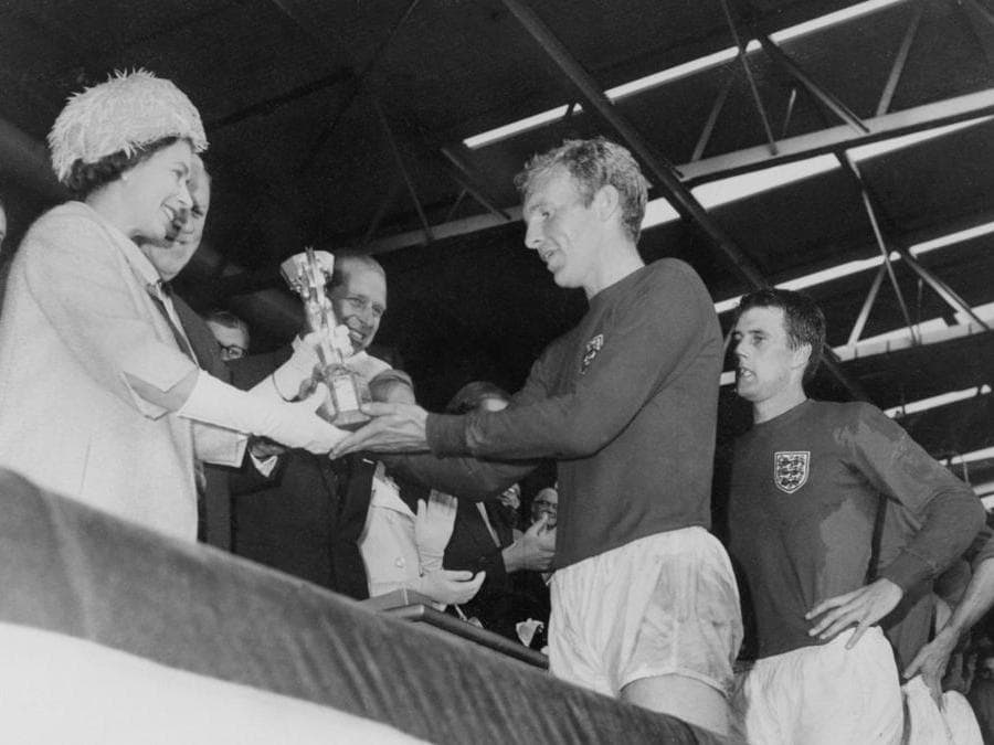 <b>1966. INGHILTERRA. Primo titolo mondiale.</b> Il capitano della nazionale inglese, Bobby Moore, riceve dalla regina Elisabetta d'Inghilterra la coppa Jules Rimet al termine della finale vinta per 4-2 contro la Germania Ovest. (Afp)
