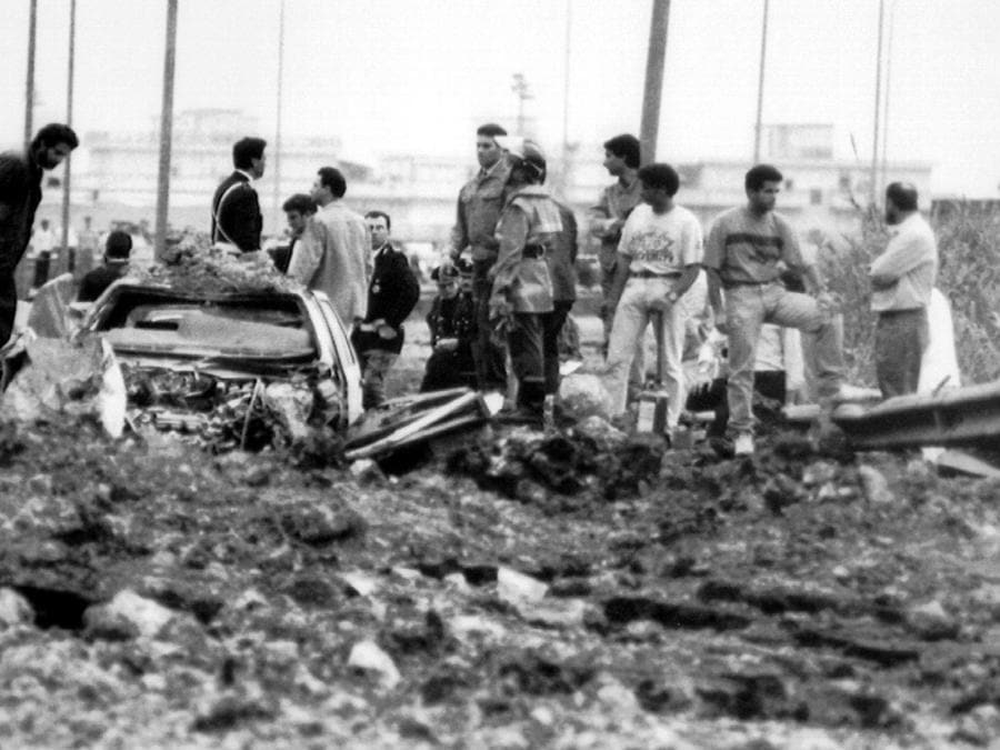 Gli investigatori sul luogo della strage del 23 maggio 1992, sull'autostrada A29, nei pressi dello svincolo di Capaci, a pochi chilometri da Palermo, dove morirono il magistrato antimafia Giovanni Falcone, sua moglie Francesca Morvillo e tre agenti della scorta, Vito Schifani, Rocco Dicillo, Antonio Montinaro. Gli unici sopravvissuti furono gli agenti Paolo Capuzza, Angelo Corbo, Gaspare Cervello e l'autista giudiziario Giuseppe Costanza (ANSA)