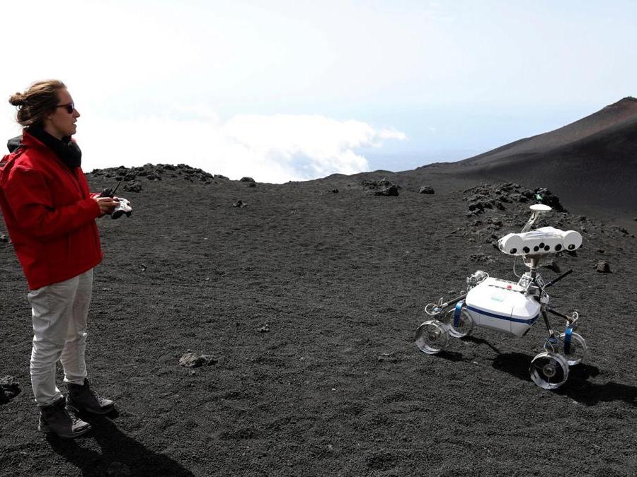 Uno scienziato del German Aerospace Center mentre controlla un robot sull’Etna. (Reuters)