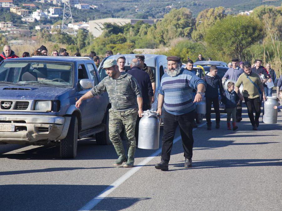 Alcuni pastori versano sulla strada il latte bloccando il traffico. Foto Italy Photo Press/Fabo Murru