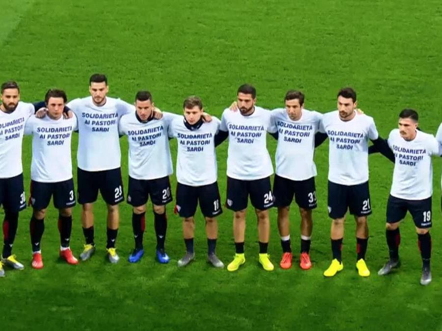 Il Cagliari porta a San Siro la protesta degli allevatori sul prezzo del latte. Prima di affrontare il Milan, i calciatori rossoblu hanno posato in campo con una maglietta bianca con scritto 'Solidarietà ai pastori sardi'. ANSA/SKY SPORT