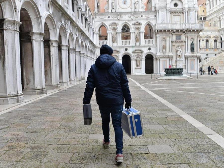 Un agente della polizia scientifica mentre lascia Palazzo Ducale a Venezia. (Ansa)