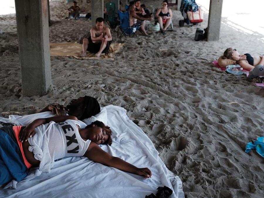 Alla ricerca di un po’ refrigerio sotto i pontili di Coney Island (Spencer Platt/Getty Images/AFP)
