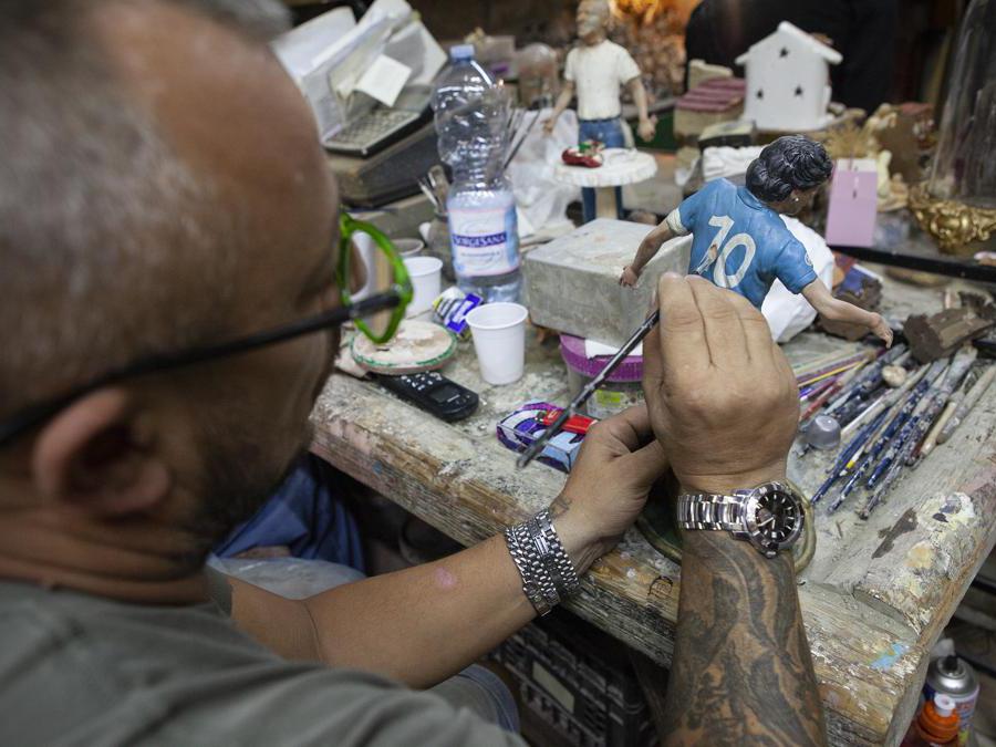 Finiture dei particolari di una statuetta realistica raffigurante Maradona all’interno della bottega storica dei fratelli Gambardella a vico Figurari. Napoli, agosto 2020. © Paolo Vezzoli