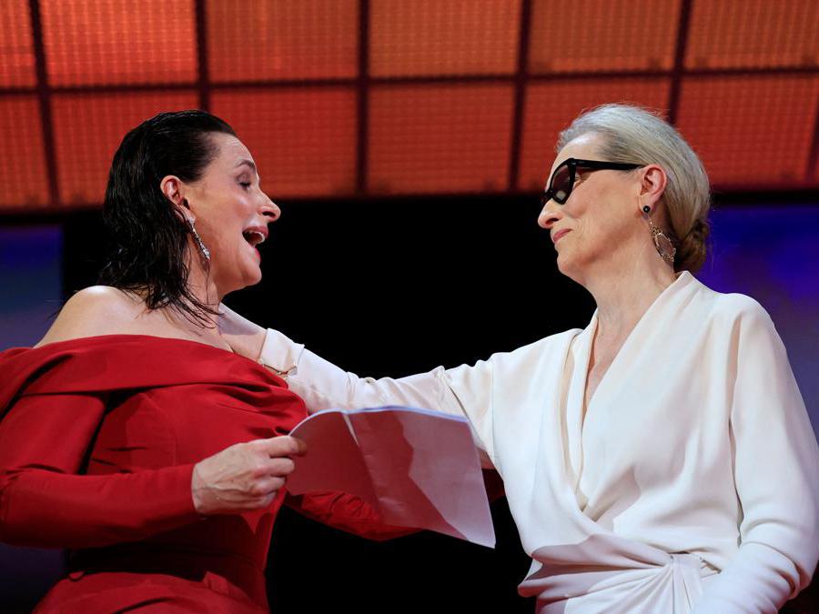 Meryl Streep riceve la Palma d’Oro Onoraria dall’attrice francese Juliette Binoche durante la cerimonia di apertura della 77esima edizione del Festival di Cannes. (Photo by Valery HACHE / AFP)