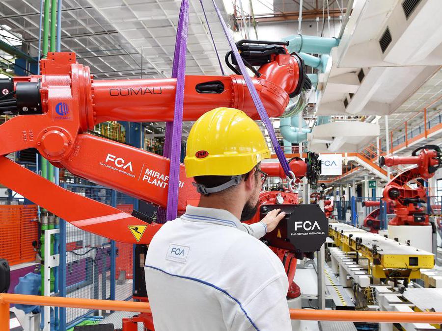 L'installazione di uno dei primi robot della nuova linea di produzione nello stabilimento di Mirafiori (Ansa/ Alessandro Di Marco)