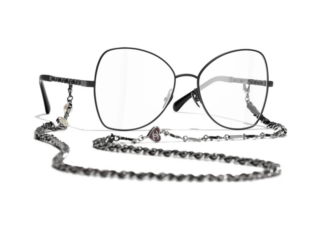 Chanel Eyewear. Occhiale grande a farfalla, in metallo nero con catena intrecciata in pelle e metallo.