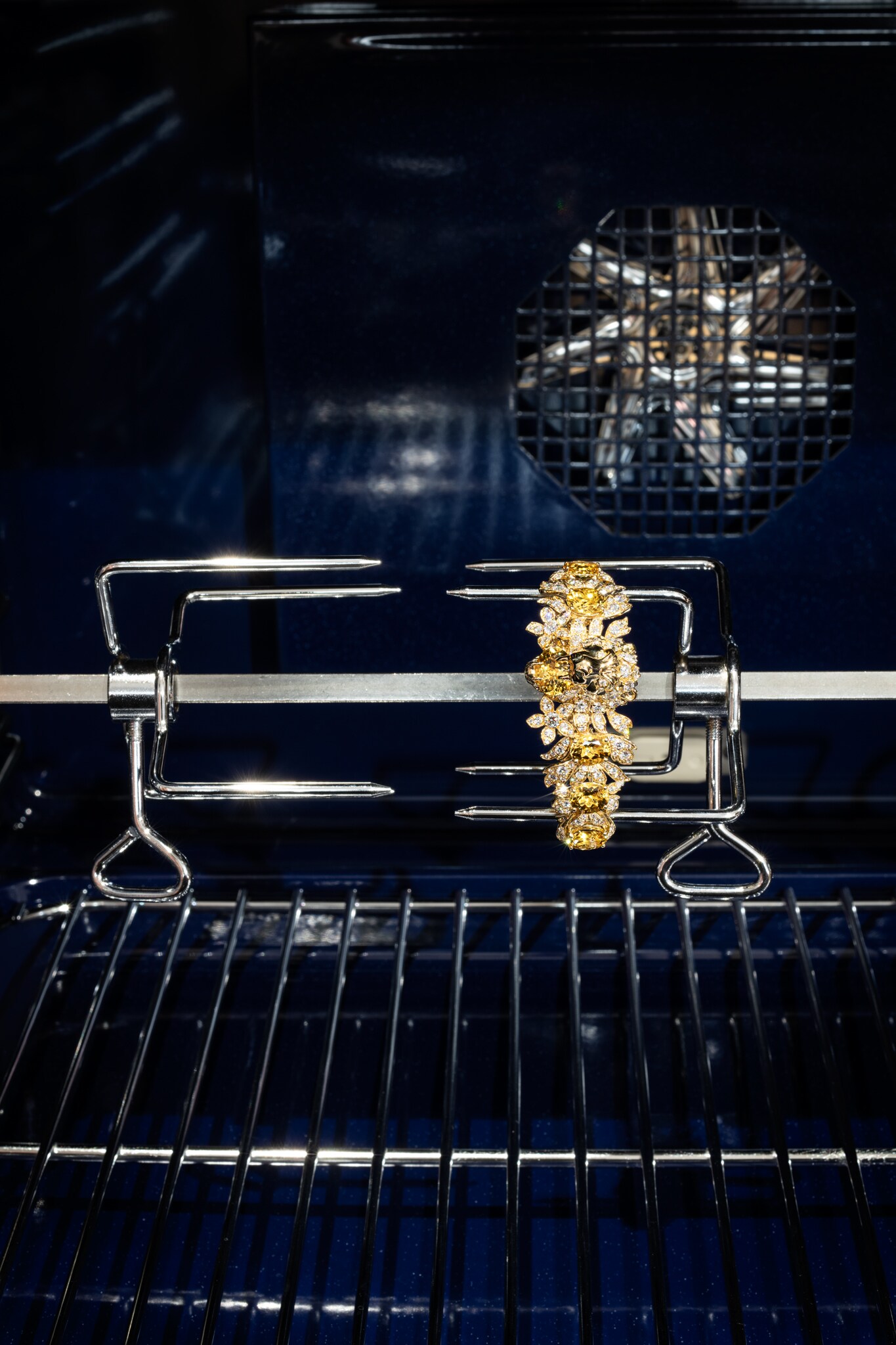 ALLO SPIEDO. Forno combinato vapore Vario 400 series GAGGENAU, con porta senza maniglia controllata da un display TFT touch control. Sono 17 i metodi di cottura a disposizione, con termosonda a tre punti di rilevazione e indicazione del tempo di cottura, a cui si aggiungono le funzioni pietra refrattaria, il girarrosto e vari programmi automatici, anche personalizzabili. Il purificatore termico filtra gli odori e le impurità dell'aria, mentre i quattro strati di vetro della porta la mantengono perfettamente isolata anche durante il programma di pulizia pirolitica a 485 gradi. Al centro, bracciale in oro giallo con 9 berilli gialli (quasi 23 ct) e 262 diamanti, Collezione Hortus Deliciarum, GUCCI HIGH JEWELRY.