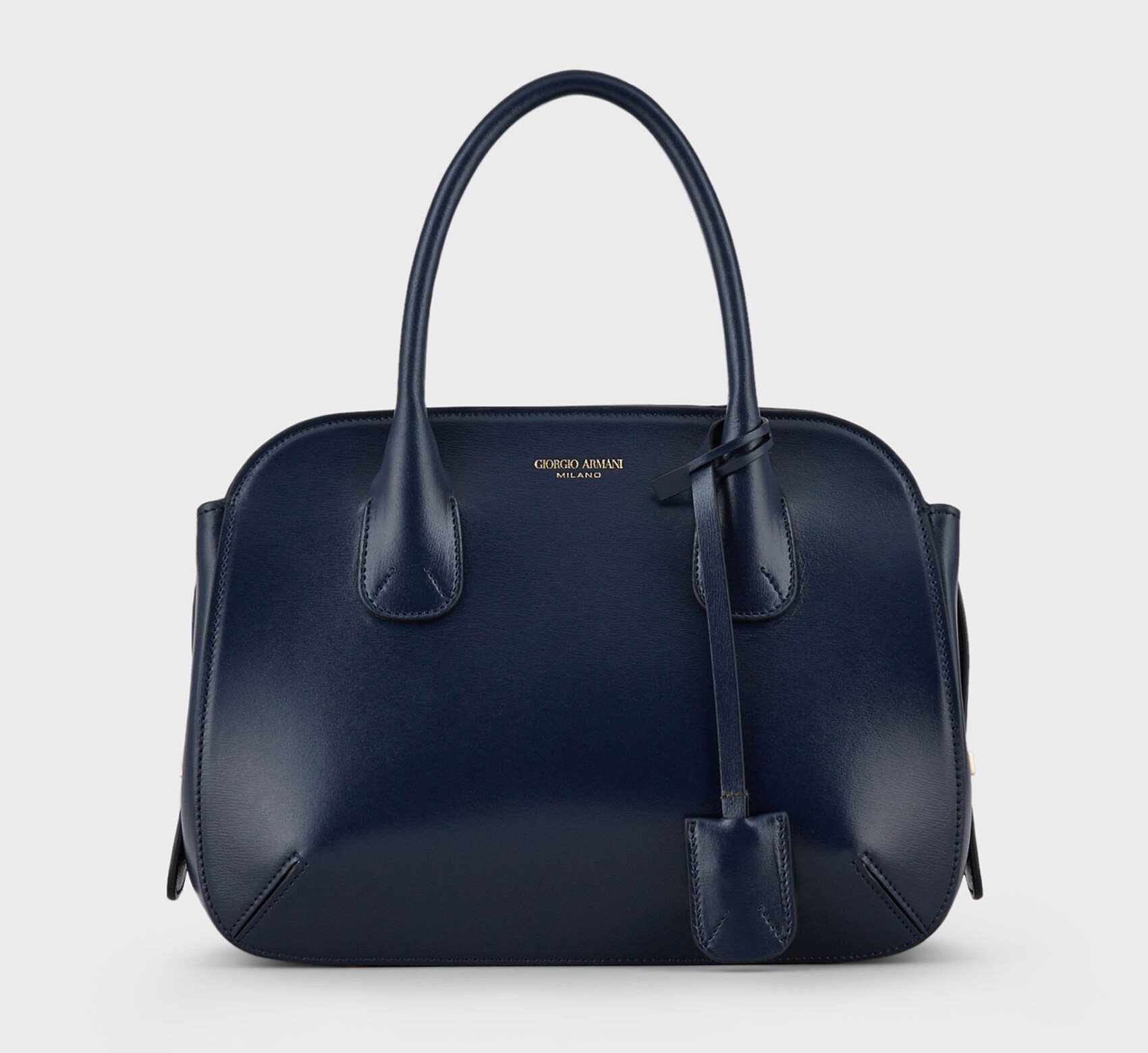 ARMANI Una riedizione della storica tote bag di Giorgio Armani uscita negli anni Ottanta, mantiene i dettagli di lavorazione delle pinces della borsa originale. I cursori della zip possono essere fermati con un lucchetto di metallo che diventa un charm (Tote bag grande la Prima in pelle palmellata, 1.750 euro, Giorgio Armani).