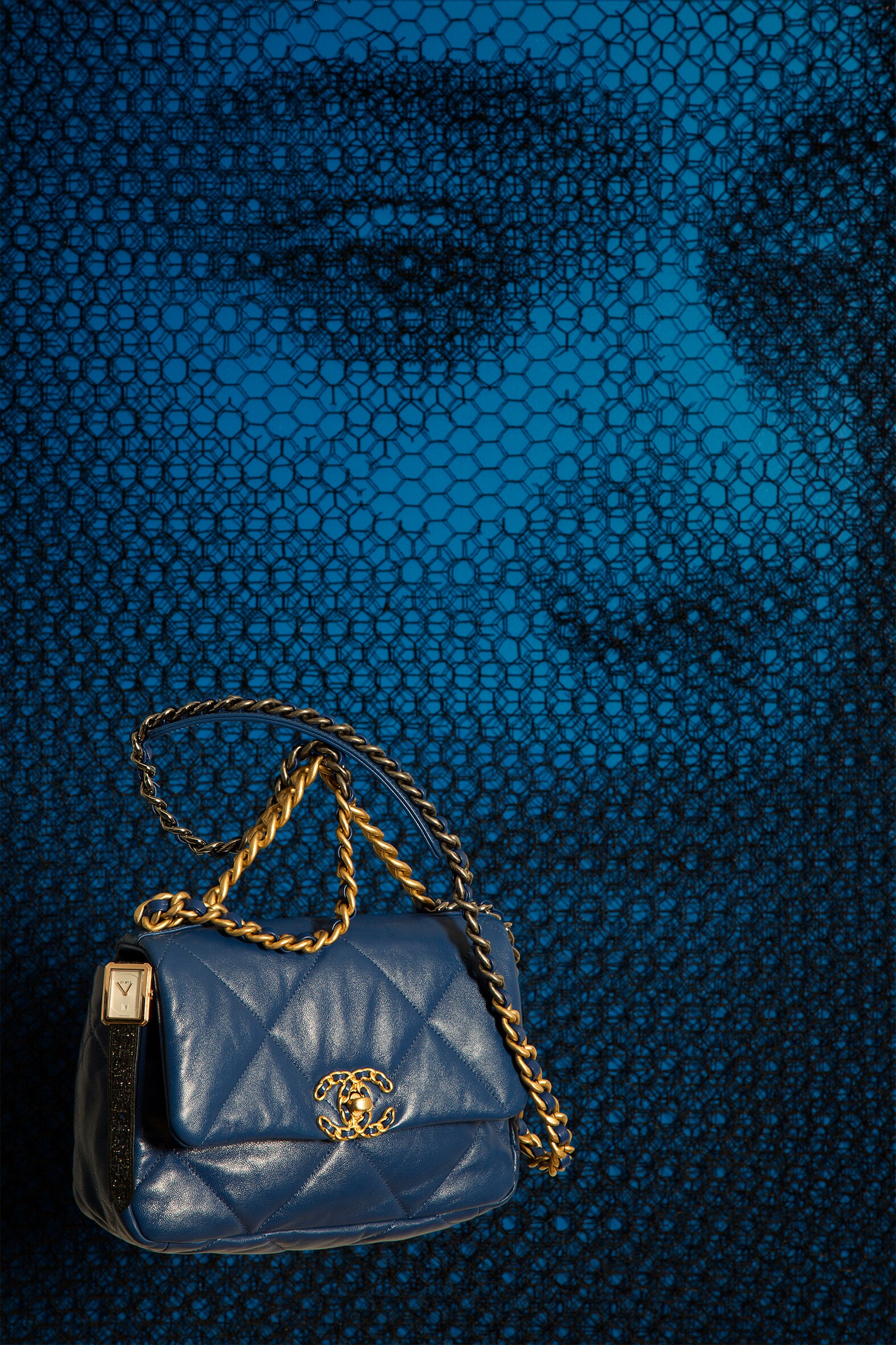 Sullo sfondo, un dettaglio dell'opera di Giorgio Tentolini, nella stanza 306 del Galleria Vik Milano Hotel. In primo piano, borsa Chanel 19, in capretto trapuntato con catene in metallo dorato, argentato e rutenio, Chanel. Orologio BoyFriend, in oro beige con cinturino in tessuto tweed e pelle, Chanel Horlogerie.