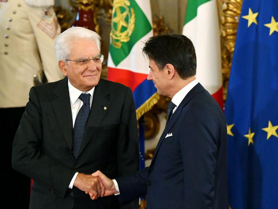 Il presidente della Repubblica Sergio Mattarella (sinistra) e il primo ministro Giuseppe Conte si stringono la mano durante la cerimonia del giuramento al palazzo del Quirinale. (Photo by Andreas SOLARO / AFP)