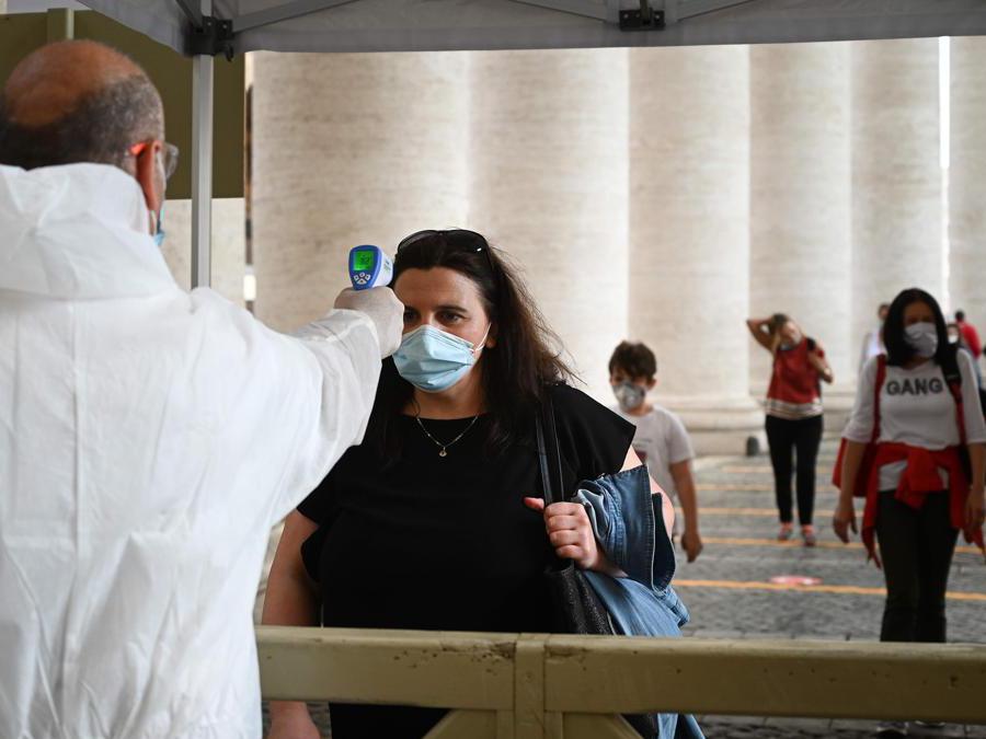 Controllo della temperatura per accedere alla Basilica di San Pietro , in Vaticano (Photo by Vincenzo Pinto / AFP)