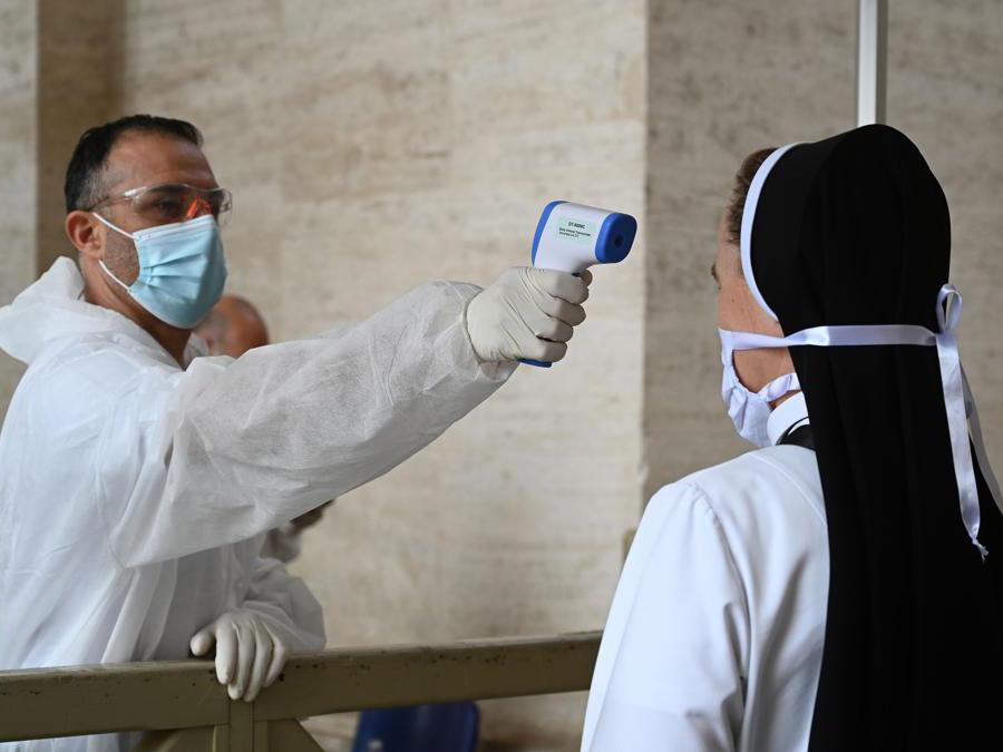 Controllo della temperatura per accedere alla Basilica di San Pietro , in Vaticano (Photo by Vincenzo Pinto / AFP)