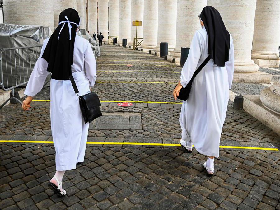 Due suore attraversano l'aera di sicurezza per accedere alla Basilica di Piazza San Pietro (Photo by Vincenzo Pinto / AFP)