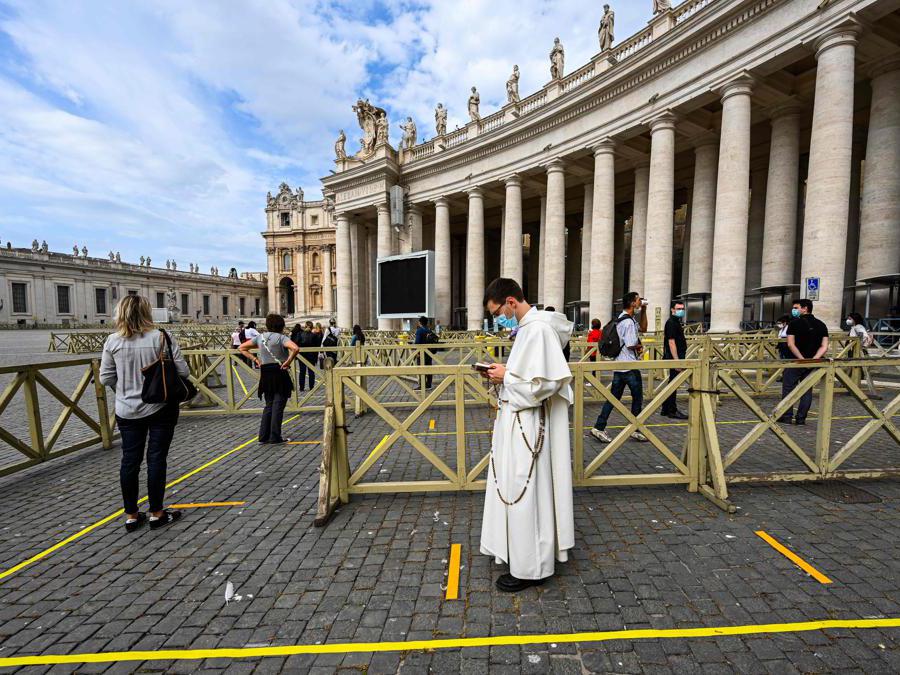 Le persone mantengono le distanze di sicurezza per accedere alla Basilica di San Pietro , in Vaticano (Photo by Vincenzo Pinto / AFP)
