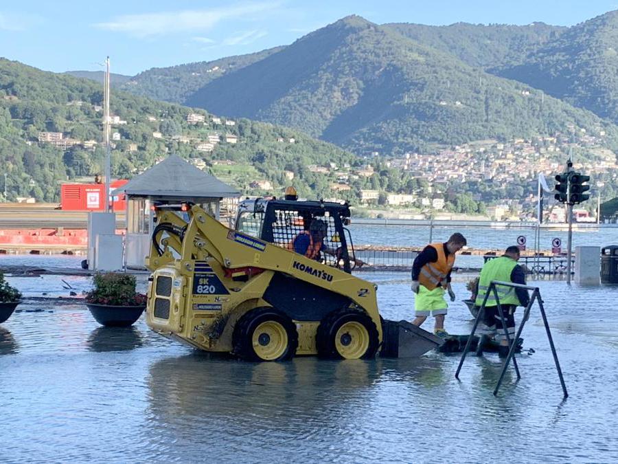 Operai al lavoro in piazza Cavour a Como ricoperta di acqua e detriti esondati dal lago a causa delle copiose piogge. (Ansa / Maatteo Bazzi) 