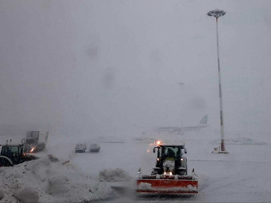 Mezzi meccanici tolgono la neve sulla pista dell'aeroporto di Linate, 28 dicembre 2020. (Ansa / Sara Bonifazio)