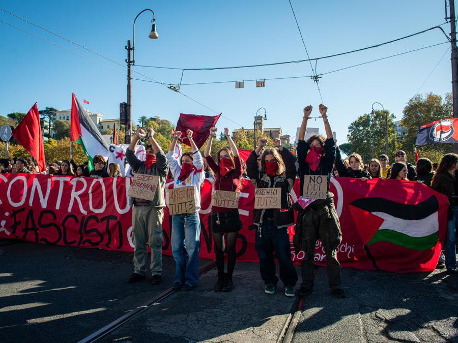 Manifestazione degli studenti a Viale Trastevere davanti al Miur. Nella foto i manifestanti con manette e cartelli dopo aver lanciato vernice rossa. (photo Valentina Stefanelli / LaPresse)