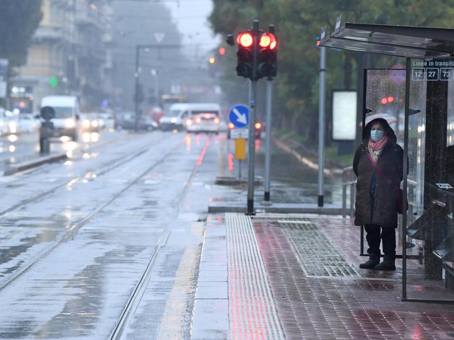 Una persona attende l'arrivo di un tram, Milano (Ansa/Daniel Dal Zennaro)