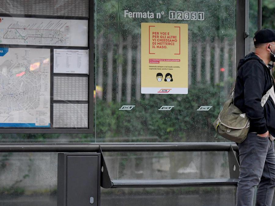 Una persona attende l'arrivo di un tram ad una fermata, Milano (Ansa/Daniel Dal Zennaro)