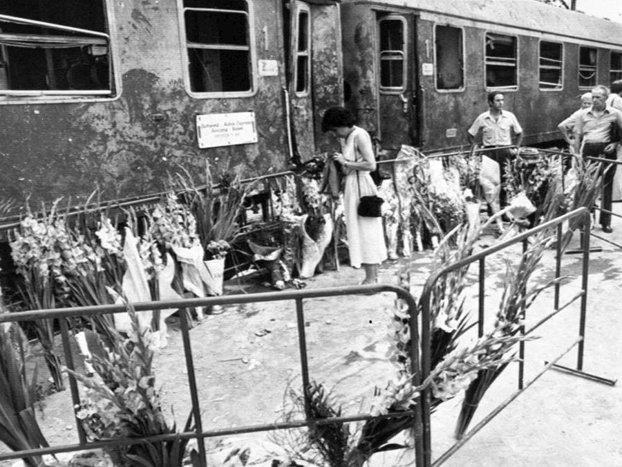 I fiori portati dai cittadini davanti alla carrozza dell'Adria Express dopo la strage di Bologna del 2 agosto 1980. ANSA.
