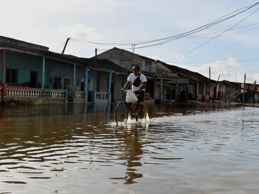 Un uomo pedala attraverso una strada allagata mentre l’uragano Milton si avvicina alla costa cubana a Batabano, Cuba. (Reuters)