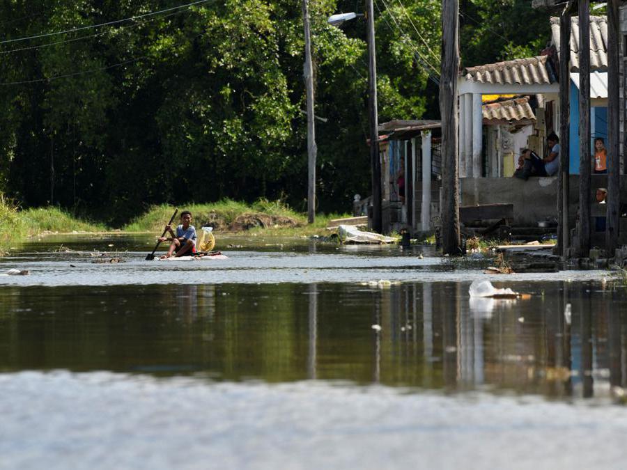 Un bambino si siede su una zattera improvvisata  su una strada allagata mentre l’uragano Milton si avvicina alla costa cubana a Batabano, Cuba. (Reuters)