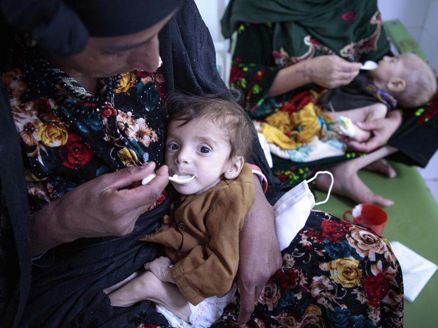 Afghanistan: Centro nutrizionale MSF ad Herat - MSB107284 – I bambini malnutriti vengono nutriti dalle loro madri nel centro nutrizionale MSF di Herat, presso l'ospedale regionale. Il centro è sovraffollato: attualmente ci sono 84 pazienti per 60 letti, alcune madri devono condividere un letto per due bambini. Ottobre 2021, Afghanistan. Ph: Sandra Calligaro. 