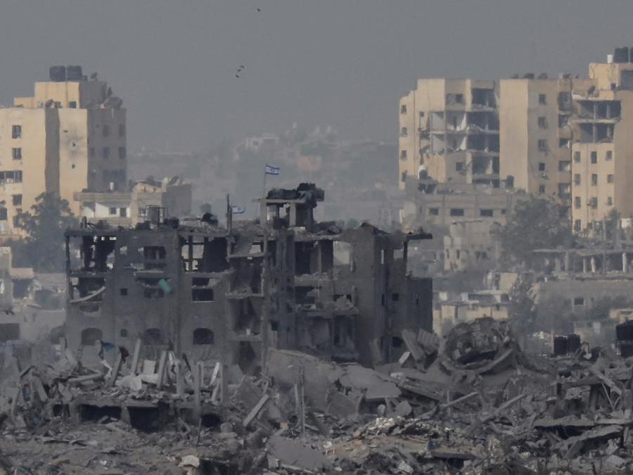 An Israeli flag flutters on a destroyed building in Gaza, as seen from southern Israel, amid the ongoing conflict between Israel and the Palestinian group Hamas, November 19, 2023. REUTERS/Alexander Ermochenko
